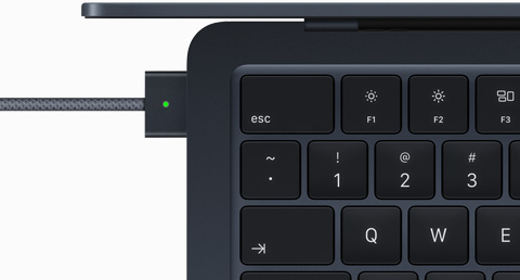 使用 MagSafe 连接线充电的午夜色 MacBook Air 俯视图