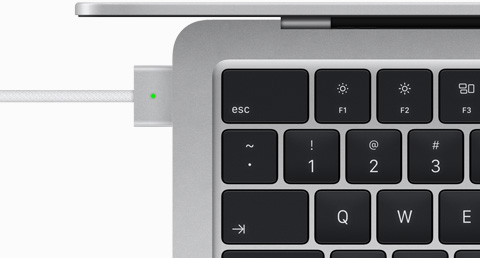 使用 MagSafe 连接线充电的银色 MacBook Air 俯视图