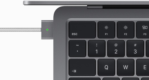 使用 MagSafe 连接线充电的深空灰色 MacBook Air 俯视图