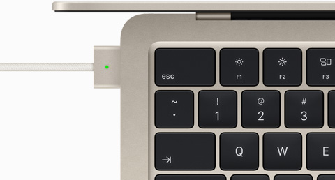 使用 MagSafe 连接线充电的星光色 MacBook Air 俯视图