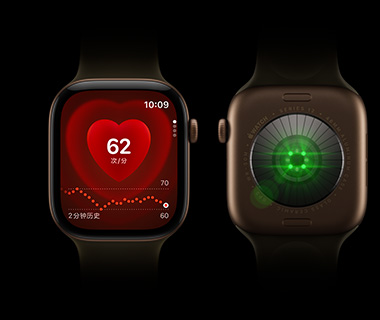 两只 Apple Watch Series 12 设备并排摆放；左侧为 Apple Watch Series 12 正面视图，屏幕显示心率监测功能；右侧为 Apple Watch Series 12 背面视图，表背发出绿光。