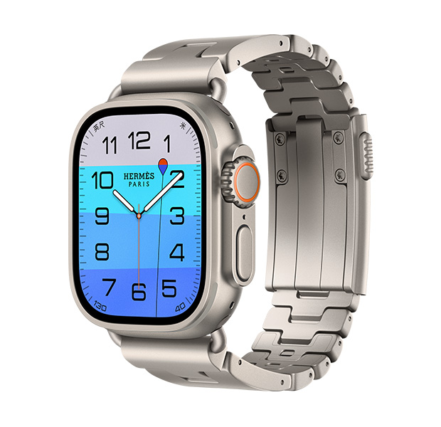 Apple Watch Hermès Ultra 4,展示 Fathom 和 Wonder 模拟表盘 (时针、分针和秒针,水深复杂功能,表盘显示一个橙色浮标在碧海上漂浮的画面,海水色调由浅蓝色渐变至中蓝色)、原色钛金属表壳、右侧外观、数码表冠、凸起的侧边按钮,搭配 Gris Titane 钛灰色 Grand H Titane 表带。
