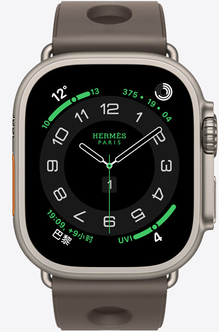 Apple Watch Hermès Ultra 3，展示原色钛金属表壳、Hermès 爱马仕 Circulaire 表盘及天气、健身记录圆环、巴黎时间和紫外线指数等复杂功能、右侧外观、数码表冠、麦克风、凸起的侧边按钮，搭配 Gris Titane 钛灰色 Scub'H Diving 表带。