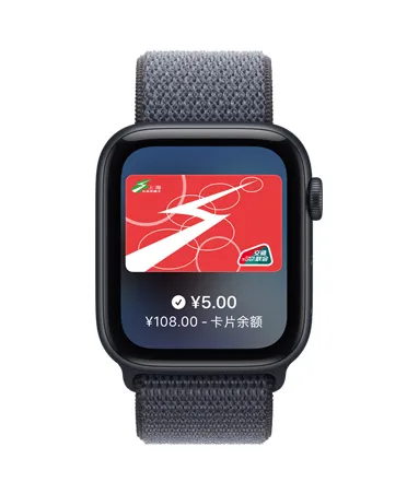 Apple Watch SE 3，展示午夜色铝金属表壳、Apple 钱包 app 中的交通卡，数码表冠位于右侧，搭配铁锚蓝色回环式运动表带。