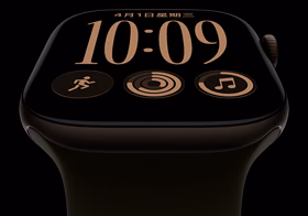 Apple Watch Series 12，展示深古铜色铝金属表壳、模块表盘、星期和日期、体能训练、健身圆环、Apple Music 复杂功能、右侧外观、数码表冠，搭配橄榄色运动型表带。