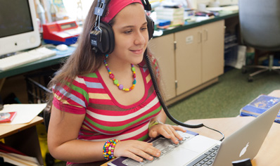 学生带着耳机使用 MacBook Pro