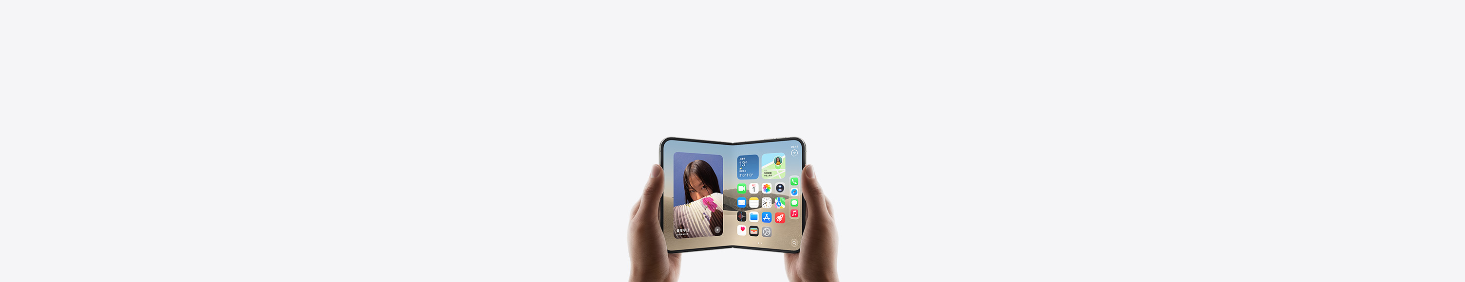 两只手拿着横向展开的 iPhone Duo，内屏显示主屏幕画面。