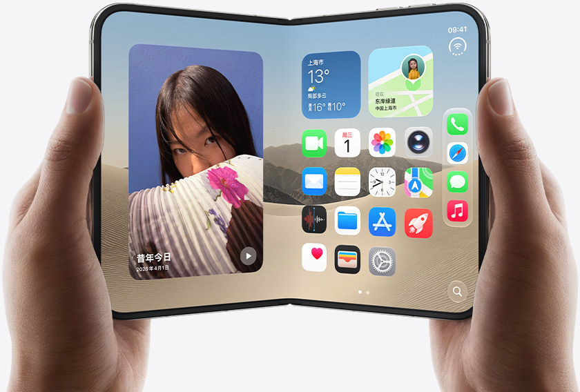 两只手拿着展开的 iPhone Duo，左侧界面显示一张女子照片，右侧界面显示主屏幕画面，其中包含信息、照片、相机和 App Store 等多种 app 图标。