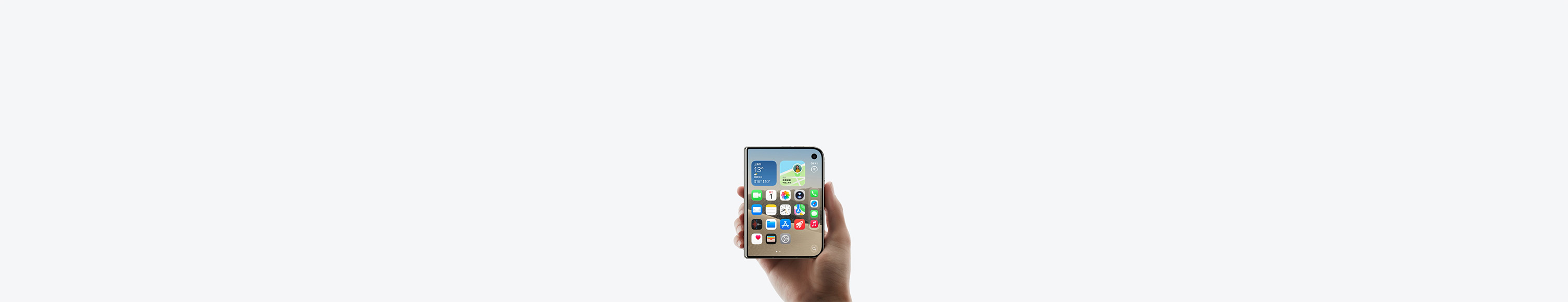 一只手握着呈闭合状态的星光白色 iPhone Duo，展示设备外屏，iOS 主屏幕画面显示多个 app 和小组件。