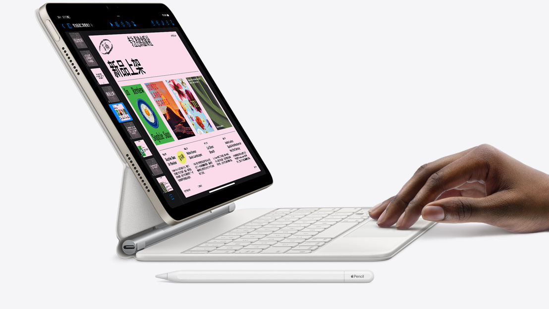 iPad Air 与妙控键盘相吸附的侧视图，屏幕上显示 Keynote 讲演 app，一只手放置在触控板上，旁边放着 Apple Pencil。