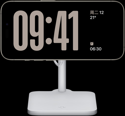 一部处于待机显示模式的 iPhone 15 Pro，正在全屏显示时钟，屏幕上还显示着日期、气温，以及下一个闹钟。