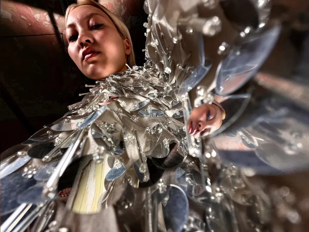 照片 app 展示 Pro 级融合式摄像头系统在不同焦距下的拍摄视角。当前切换到微距模式，镜头拍摄一位女子身穿缀满银色亮片的礼服，展示亮片装饰的细节。