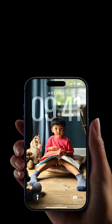 一只手拿着 iPhone 17 Pro，个性化的锁定屏幕显示照片墙纸和时间数字。