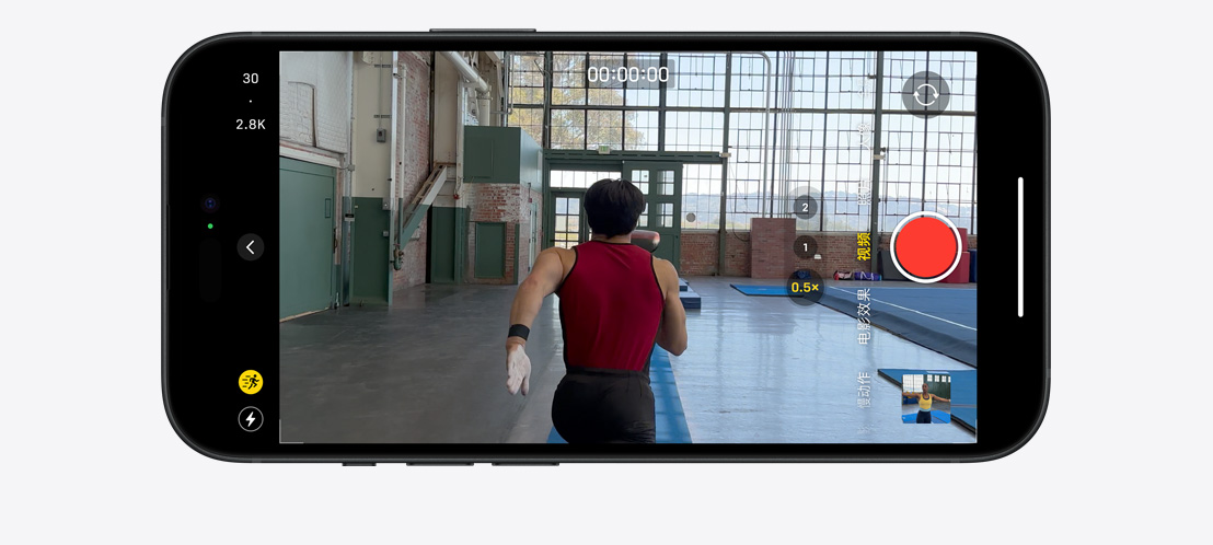 图片展示 iPhone 15 Pro 用运动模式拍摄视频，画面上一位体操运动员正在宽敞明亮的房间里奔跑。