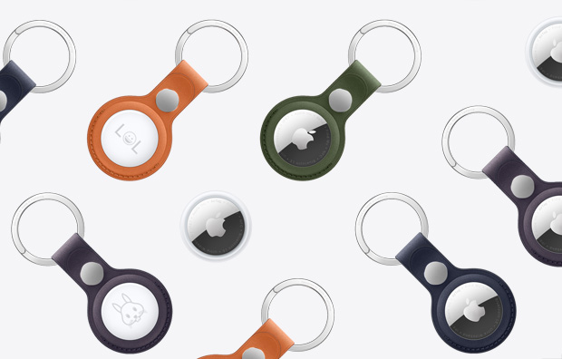 一组 AirTag 和配有各色精织斜纹钥匙扣的 AirTag，钥匙扣的配色包括橙色、暗绿色、深蓝色、黑莓色和黑色。