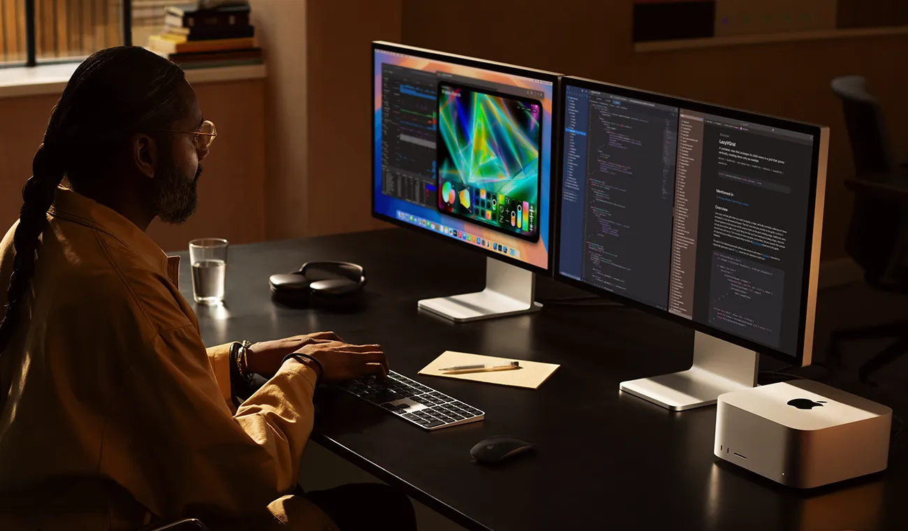 一位专业人士正在用 Mac Studio 和两台 Studio Display 显示器工作。