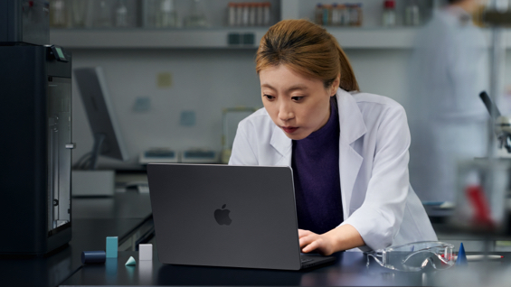 照片展示一位女生在实验室中使用 Macbook Pro。
