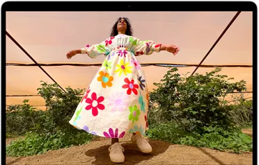 MacBook Air 屏幕上显示身穿多彩衣服的人的照片，展示 Liquid 视网膜显示屏的色彩范围和分辨率。