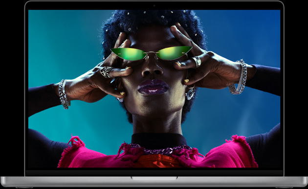 呈打开状态的银色 MacBook Pro，屏幕显示人物图像。