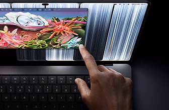 配备 PROLED XDR 显示屏的 MacBook Pro，深空黑色外观，展示用户用手指触控屏幕调整窗口大小。