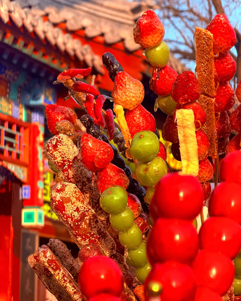 盛开的花朵、街边的糖葫芦以及灯笼映照下的小朋友构成三种不同的新春场景。色彩鲜艳的节日元素在光影中呈现。图一由李文超用 iPhone 17 拍摄；图二由张敬宜用 iPhone 17 Pro Max 拍摄；图三由李硕用 iPhone 17 Pro Max 拍摄。