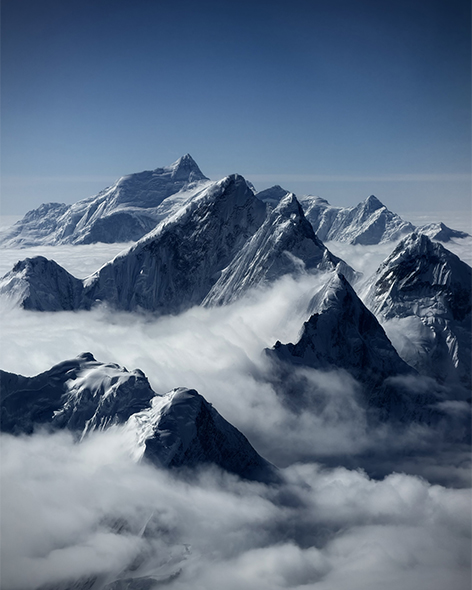 云层环绕群峰，山体自云海中显露，远处山脉在光线中延展开来。画面呈现出高海拔地貌与流动云雾交织的自然景象。由摄影师李硕用 iPhone 17 Pro Max 拍摄。