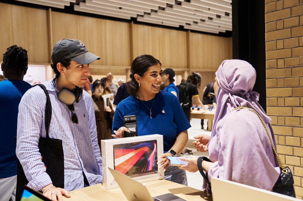 一位 Apple 团队成员帮助顾客选购 MacBook Pro。