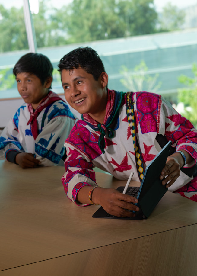 两名学生 Hugo Enrique Montes de la Cruz 和 Filiberto de la Cruz Ramirez 在瓜达拉哈拉大学里，de la Cruz Ramirez 拿着 iPad 和 Apple Pencil。