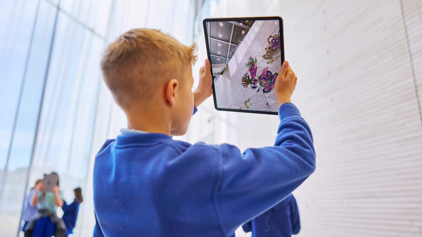 小朋友使用 iPad Pro 上的 Deep Field app 与墙壁互动。