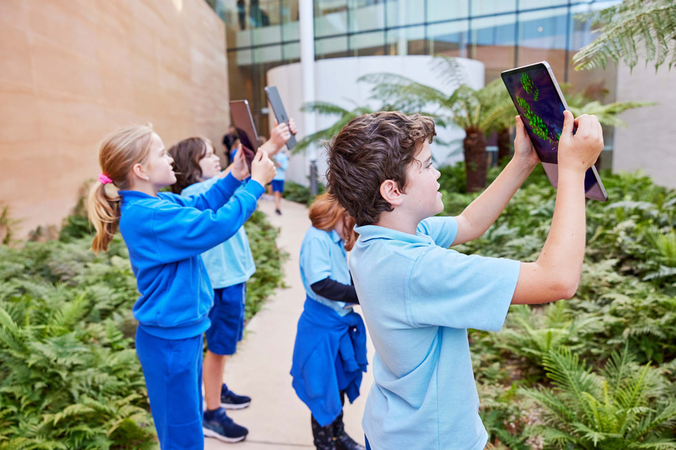 学生举起 iPad Pro ，在 Deep Field app 里探索身边的世界。