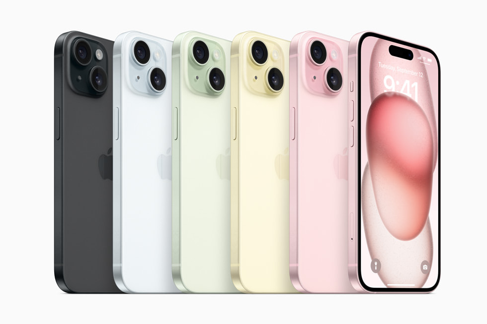 多台 iPhone 15 设备摆成一排，展示出该系列的全新彩色外观：黑色、蓝色、绿色、黄色、粉色。