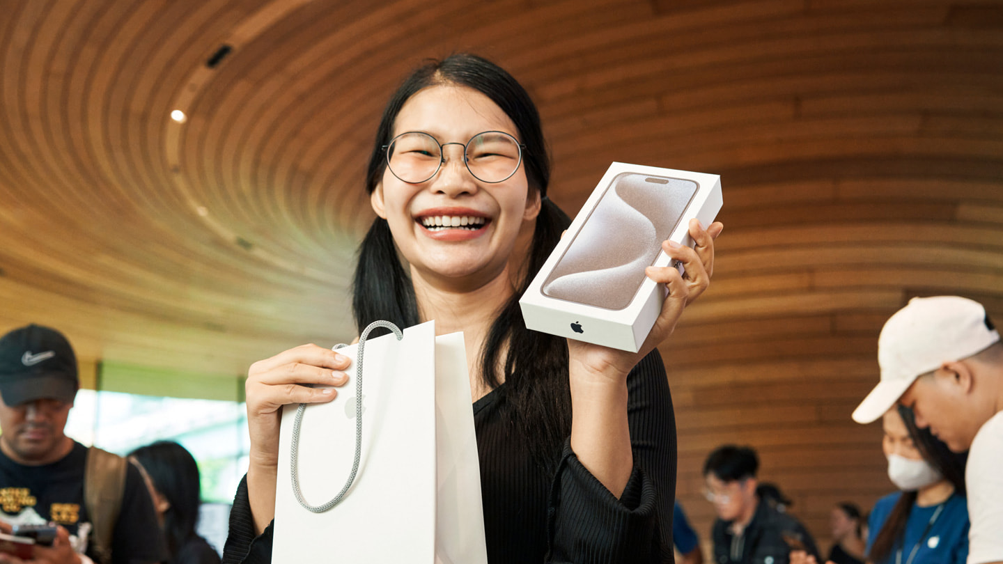 一位顾客在曼谷 Apple Central World 零售店展示新购入的 iPhone 15 Pro Max。
