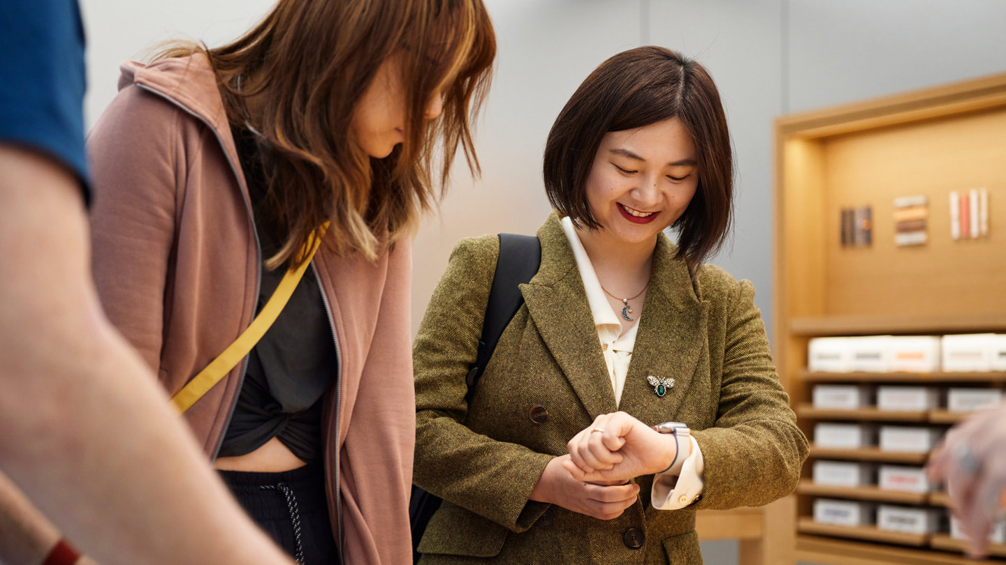 澳大利亚 Apple 悉尼零售店内，两位顾客正在试戴 Apple Watch Ultra 2。