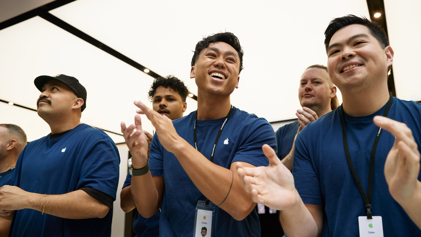 澳大利亚 Apple 悉尼零售店内，团队成员鼓掌欢迎顾客光临。