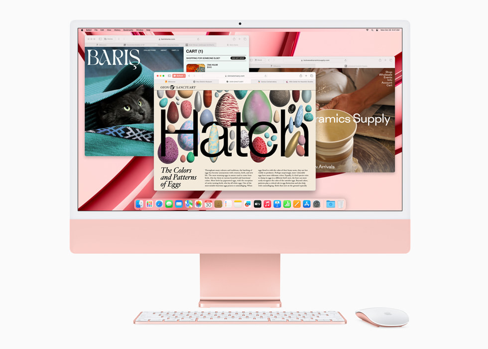 图中是 Safari 浏览器 app 的画面，显示在搭载 M3 芯片并搭配同系列配色键盘和鼠标的粉色新款 iMac 的显示屏上。