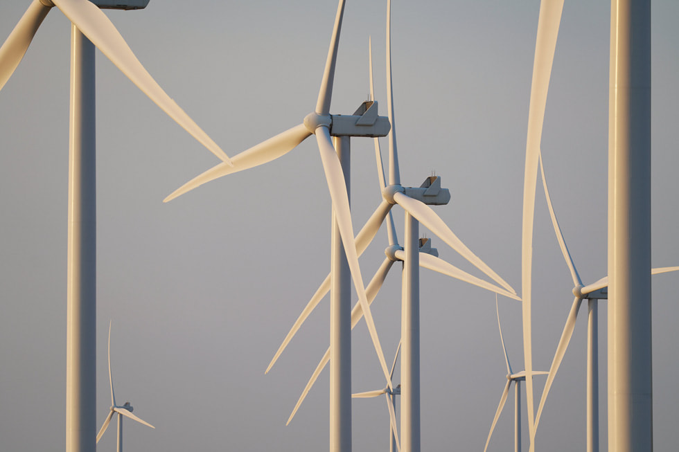 蓝天下，俄勒冈州一处风电场中的多个白色风力发电机。