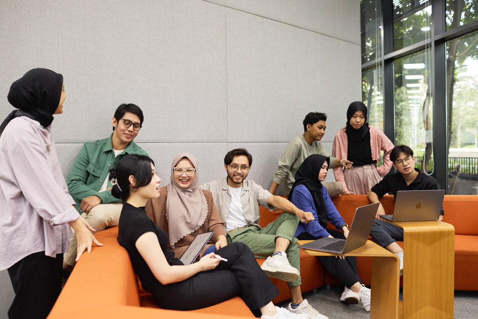 九名 Apple 开发者学院学生在教室里。