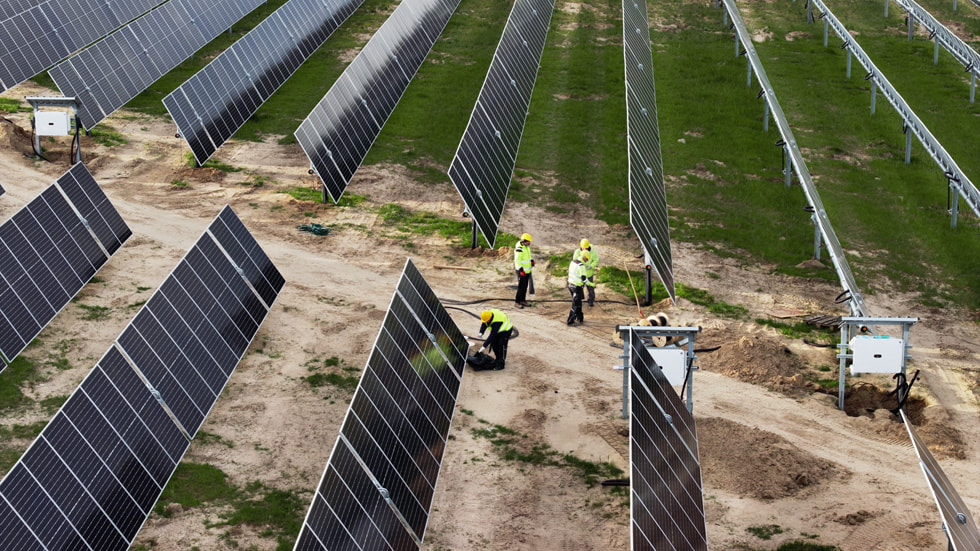 田野中的太阳能电池板和工人。