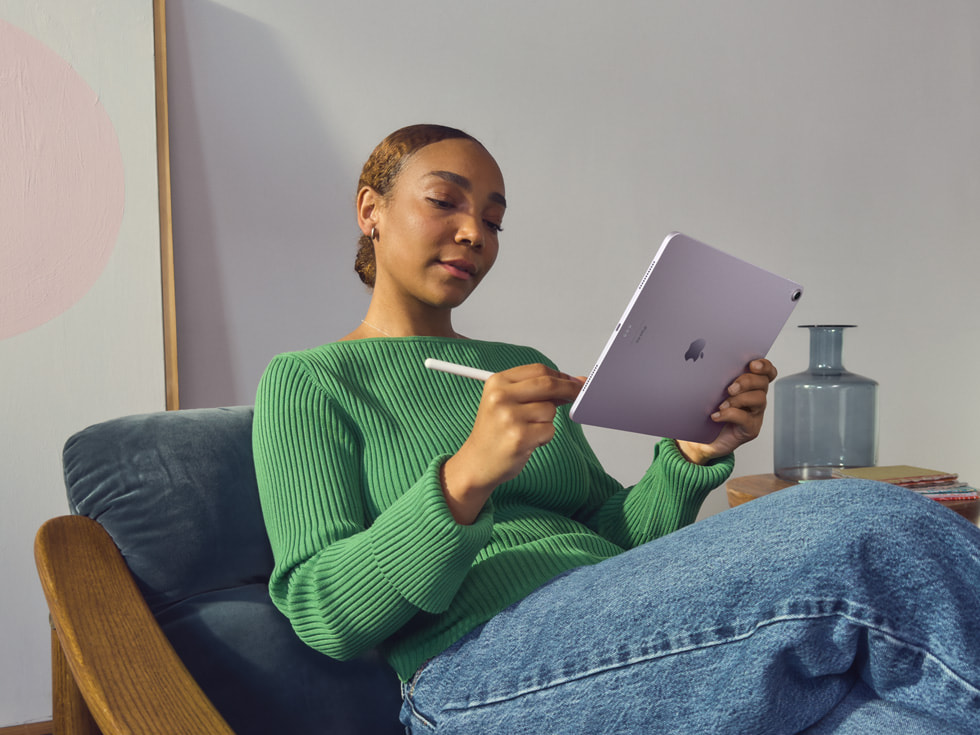 一名创意工作者在家庭办公室里使用 Apple Pencil Pro 在新款 iPad Air 上操作。