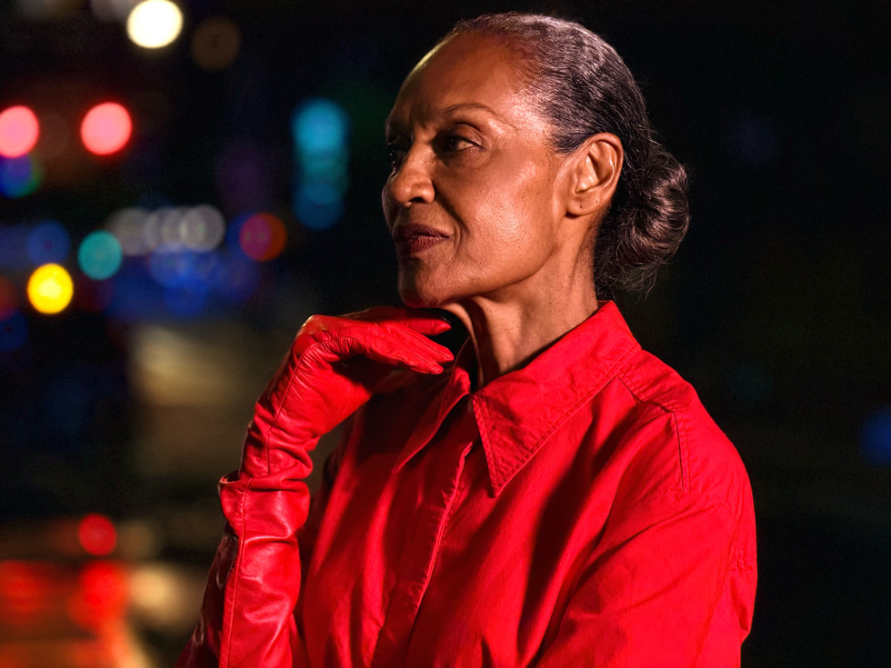 使用 iPhone 17 Pro 拍摄的弱光环境照片，画面中有一个人站立在夜幕下的街道上。