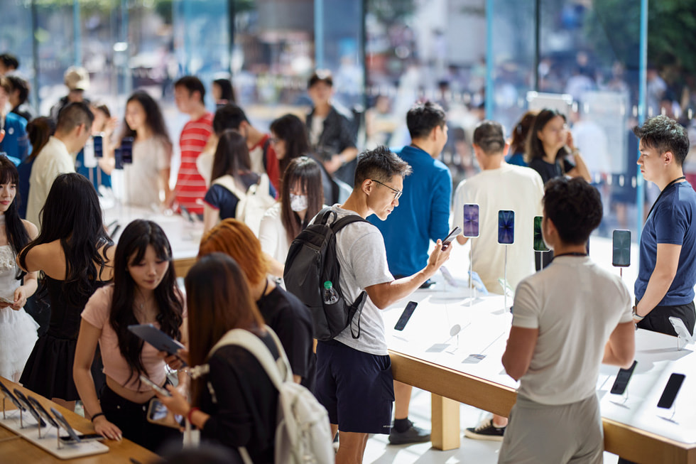 上海 Apple 南京东路零售店内，顾客在探索最新 iPhone 系列机型。