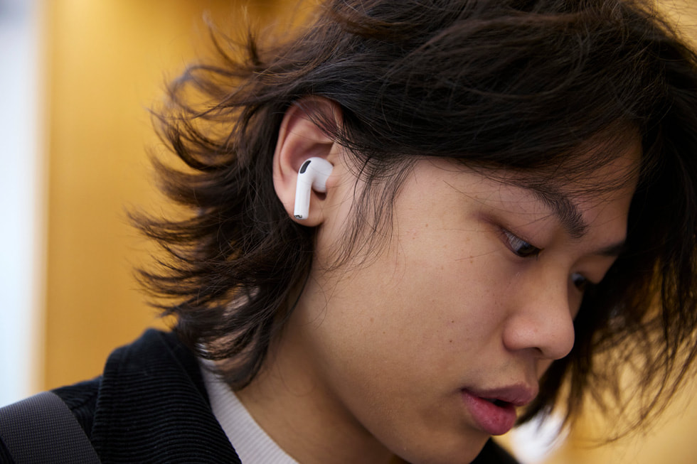 位于澳大利亚悉尼的 Apple 悉尼零售店内，一位顾客在试用 AirPods Pro 3。