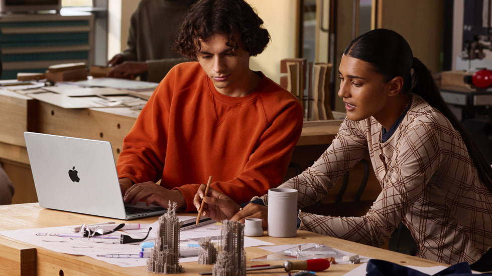 生活方式照片，展示两名用户正在使用全新 14 英寸 MacBook Pro，以及各种速绘及建筑模型。