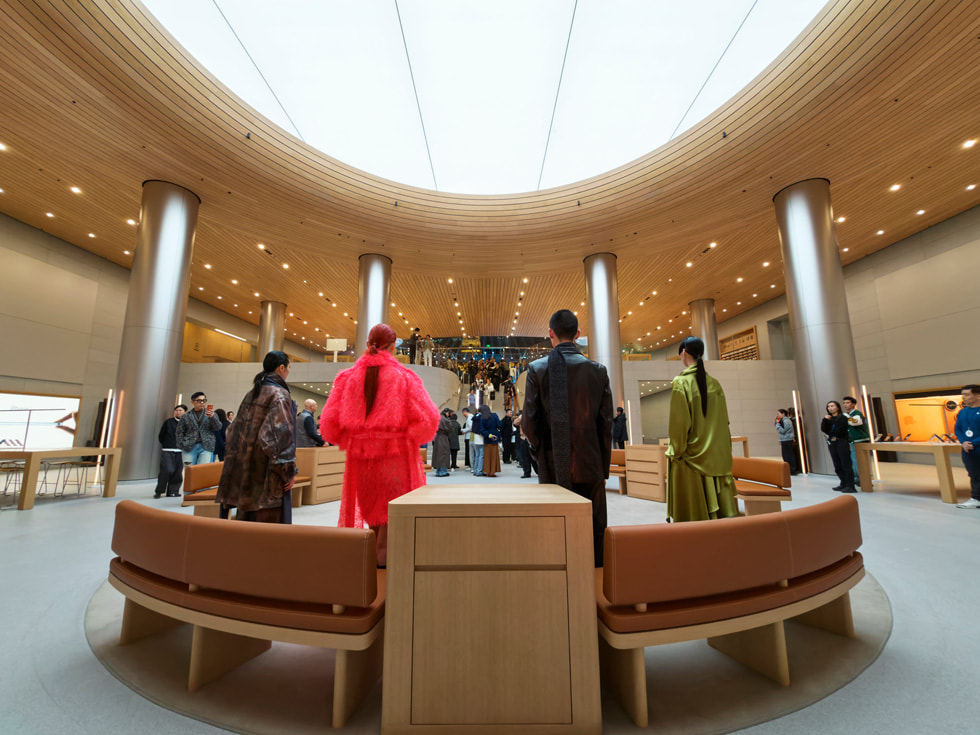 模特们背对镜头，站在 Apple 静安零售店内。