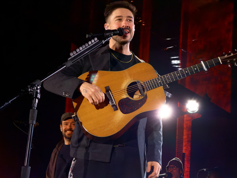 Marcus Mumford 在伦敦 Apple Battersea 零售店边弹吉他边唱歌。