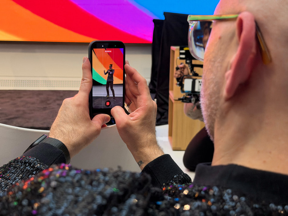 华盛顿特区 Apple Carnegie Library 零售店内，一名活动参与者正在用 iPhone 拍摄视频。