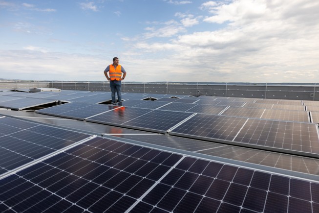 在居住区和森林覆盖的山脚下的太阳能电池板。