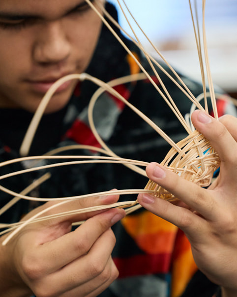 图中一名学生正在练习篮筐编织。