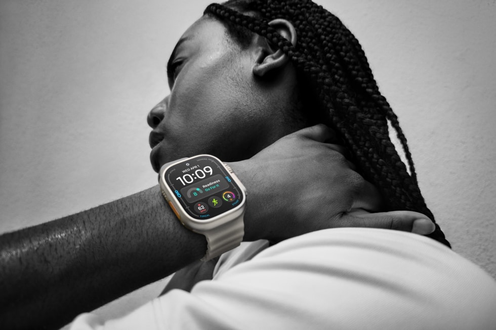 黑白照片：用户佩戴 Apple Watch Ultra 4，屏幕上醒目显示着可操作建议“火力全开”。