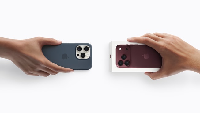 一只手拿着一部不在包装内的 iPhone 设备，另一只手拿着一部未拆包装的 iPhone 18 Pro。